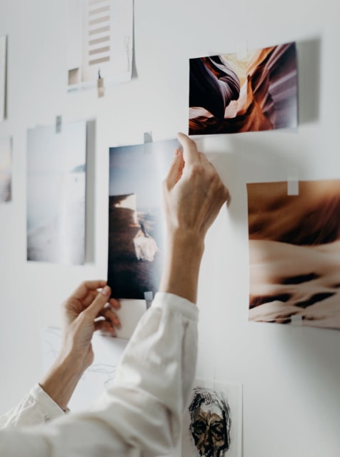 desktop image of hands sticking a printed image on the wall for brainstorming ideas